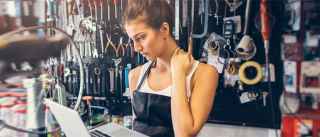 female bike repair shop owner look seriously at laptop