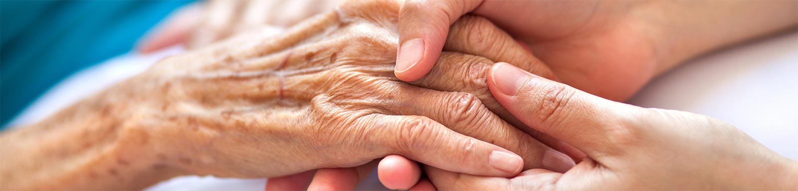 young woman holding elderly womans hand