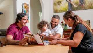 Jonathan Thurston sitting with a family at dining table