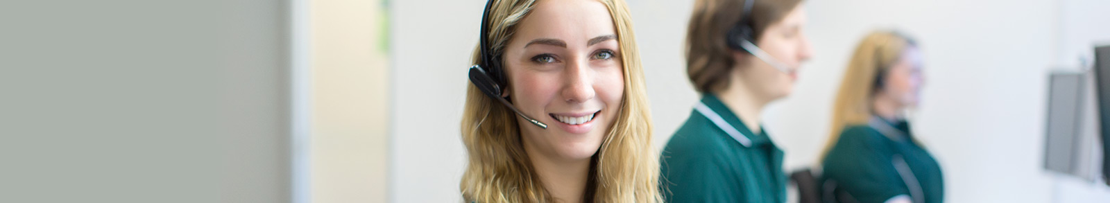 Suncorp employees wearing headsets and smiling 