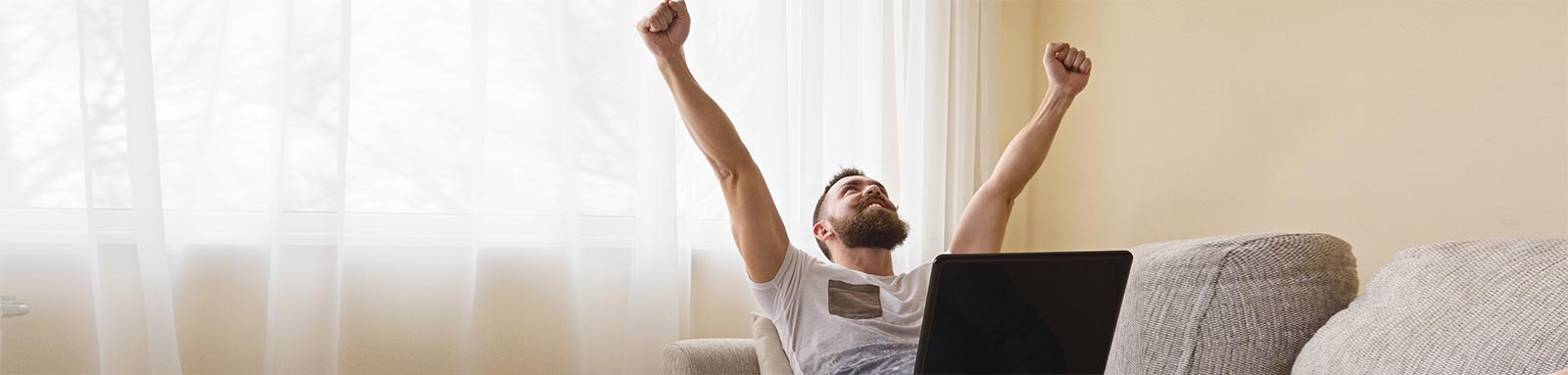 Happy freelancer celebrating on couch