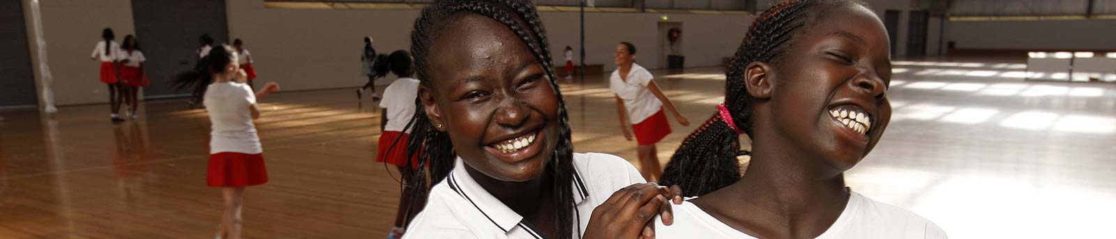 Two netball girls on court smiling