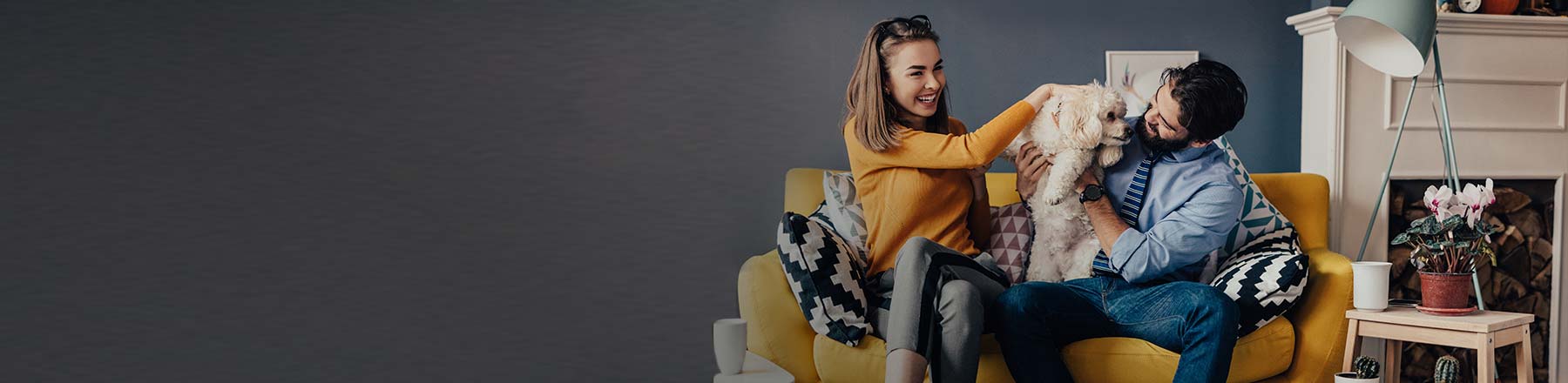 Couple with a dog on a yellow couch