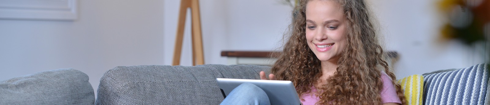 Girl with ipad sitting on a couch