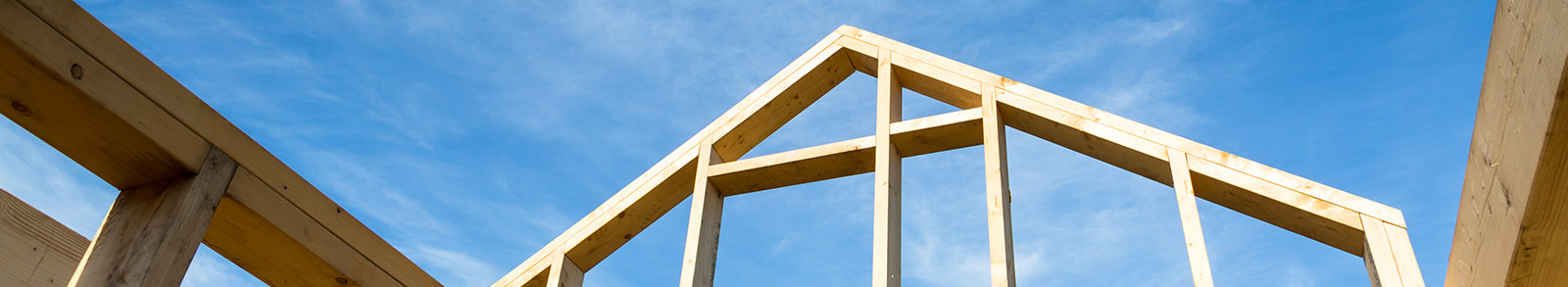 A house frame of wooden in front of blue clear sky
