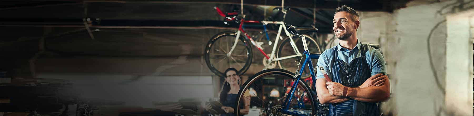 Man smiling and standing next to bikes