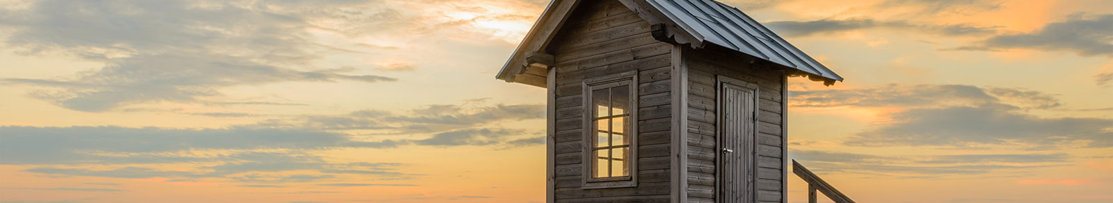 A small wodden house with light orange colour sky