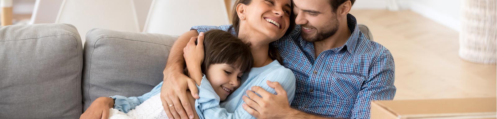 Family sitting on couch with moving boxes around