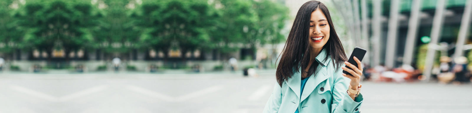 Woman holding a mobile phone on the street