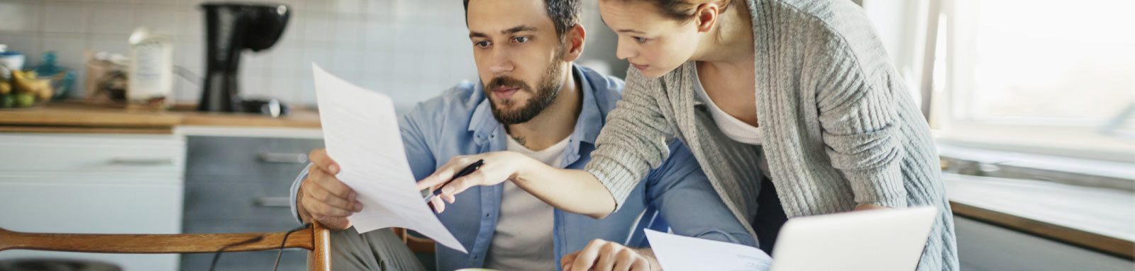 Couple in the kitchen looking at paper documents