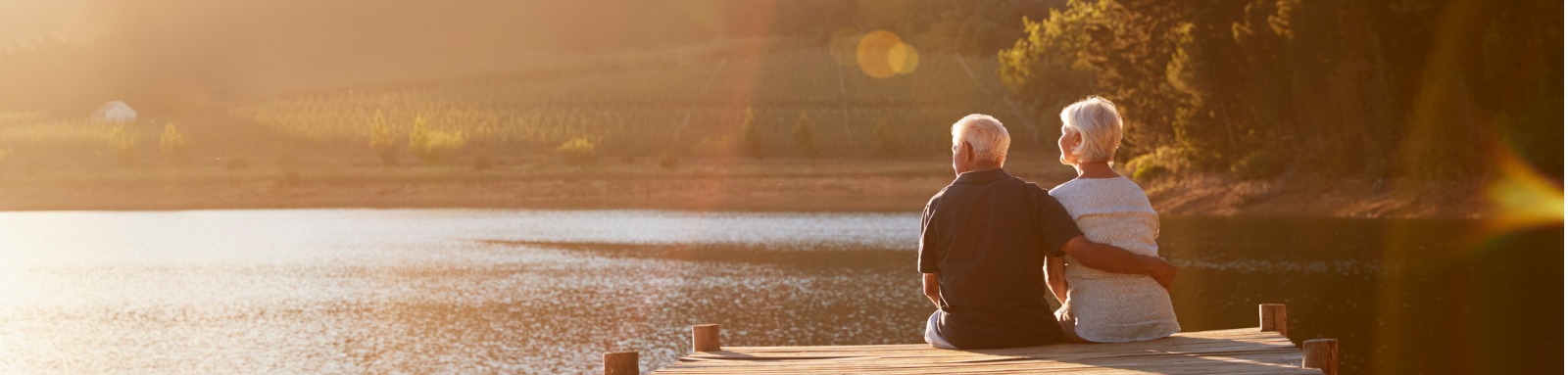 Couple sitting on a dock looking out at lake