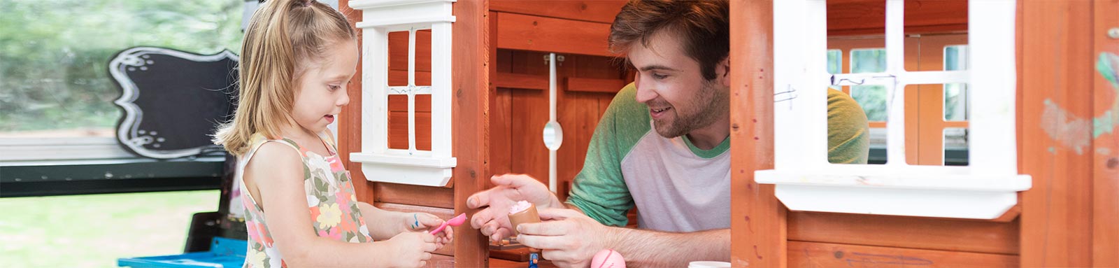 Father and daughter playing in cubby house