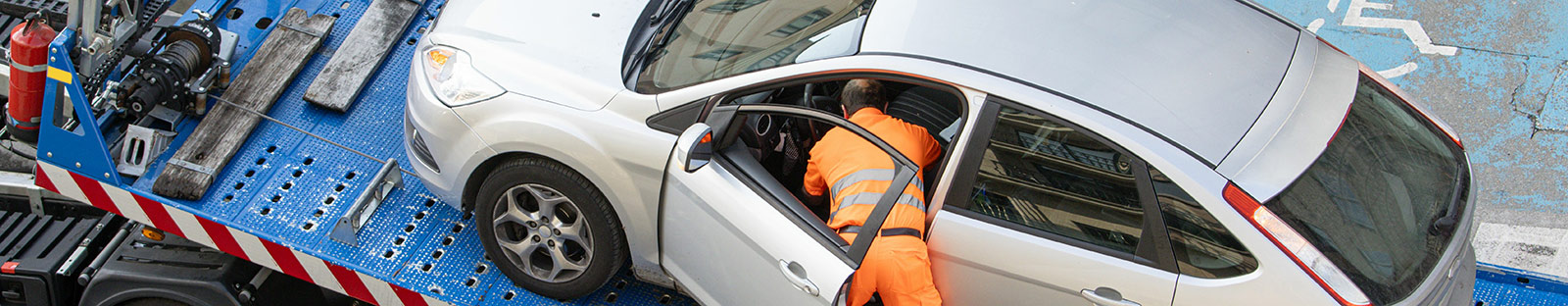Damaged car being loaded onto tow truck