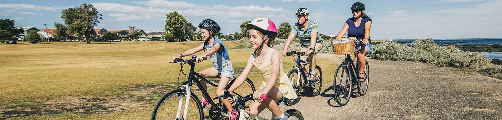 Family riding their bikes along water