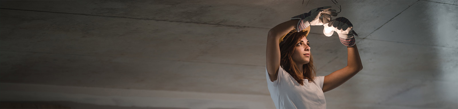 Electrician chanign a ceiling light bulb