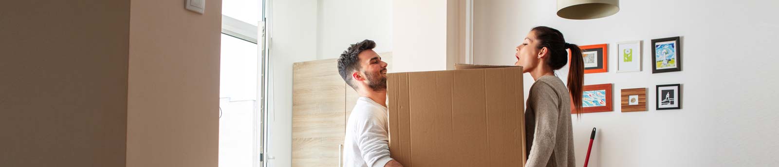 Woman and man listing a moving box in their home