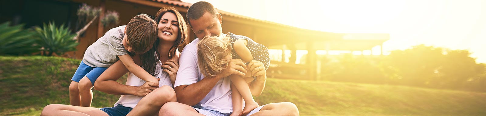 Happy family on a lawn in front of a house