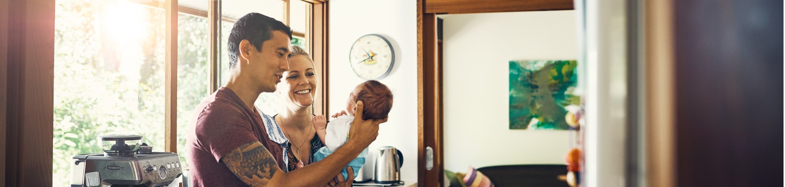 Man and woman holding baby in kitchen