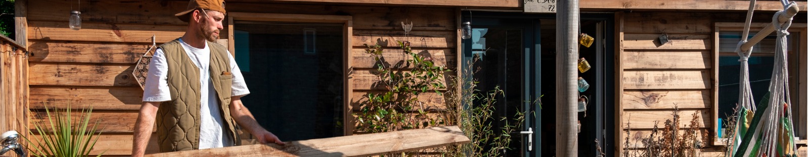 Man carrying wooden board outside timber granny flat