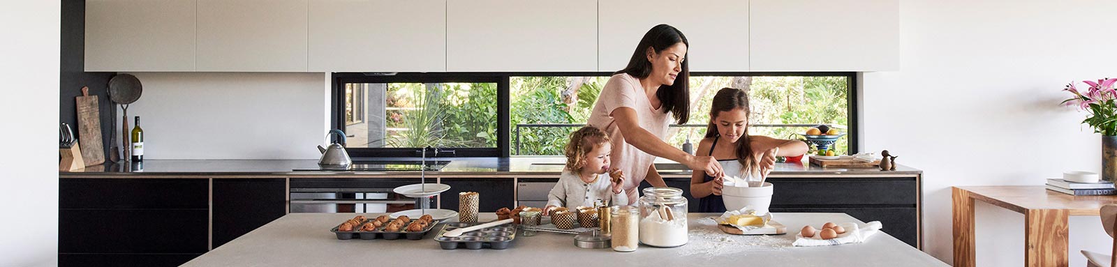 Mother and children in the kitchen making a cake