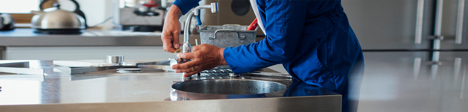 Plumber fixing kitchen tap