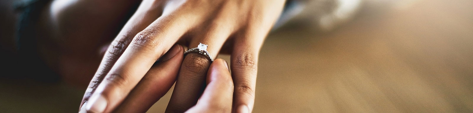 Placing an engagement ring on woman's finger