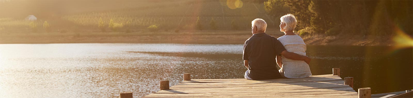 Elderly couple sitting on a dock by the lake