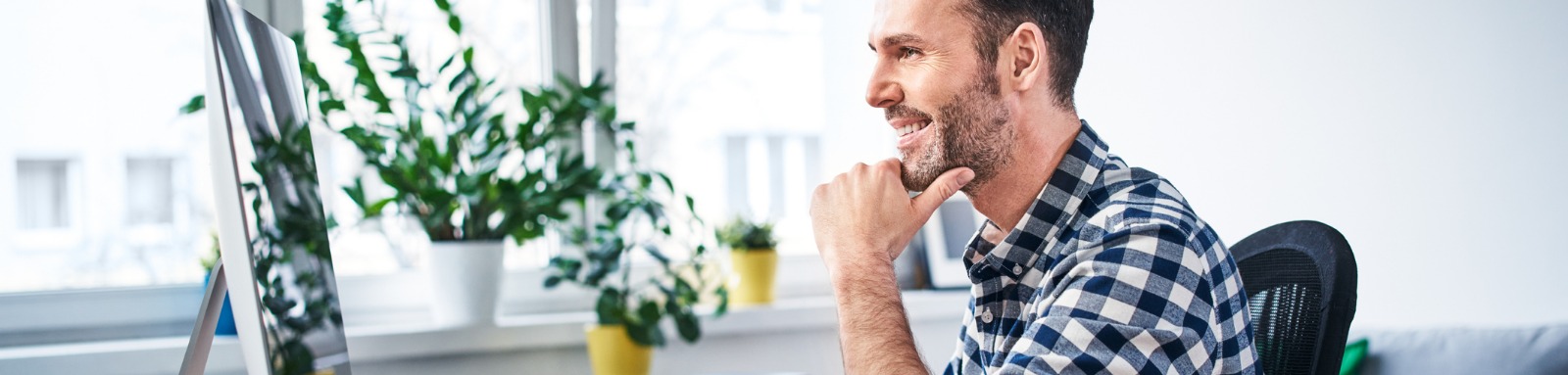 Smiling man looking at computer screen