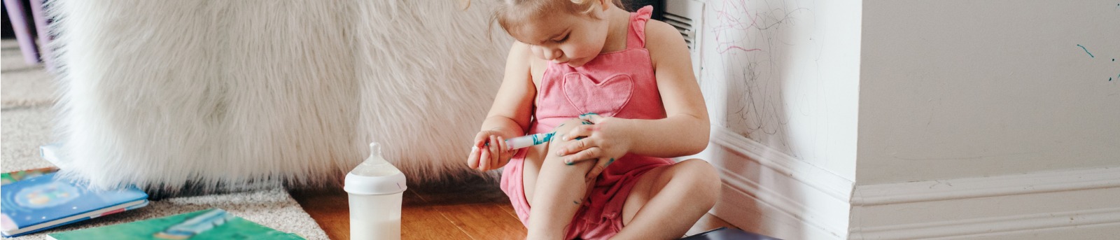 Toddler drawing on herself and the house walls with coloured markers
