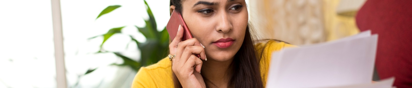 Woman looking at documents while talking on the phone