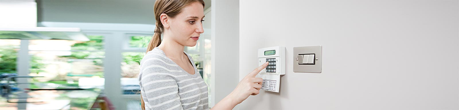 Woman setting home security device