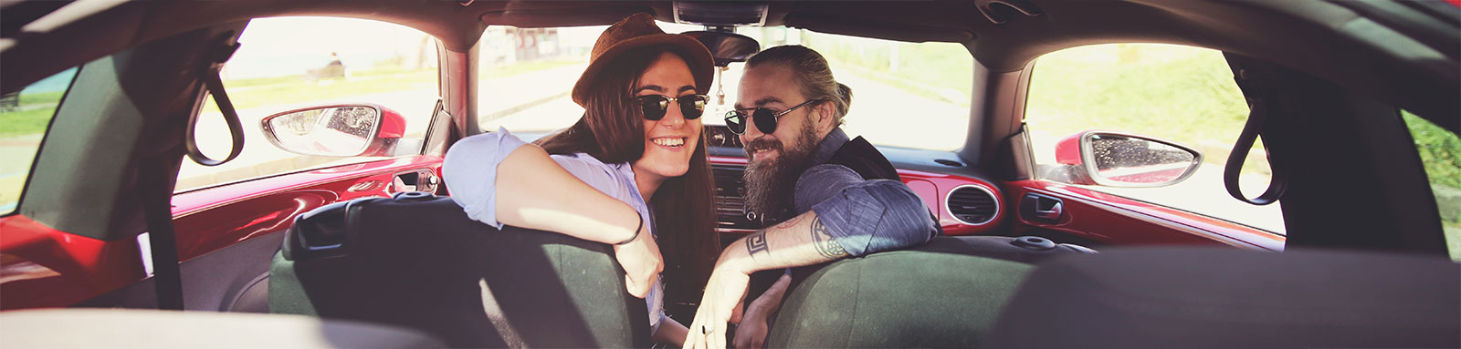 Young couple looking at the back of the car from the front seat