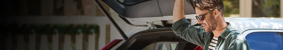 Man standing next to car with boot open