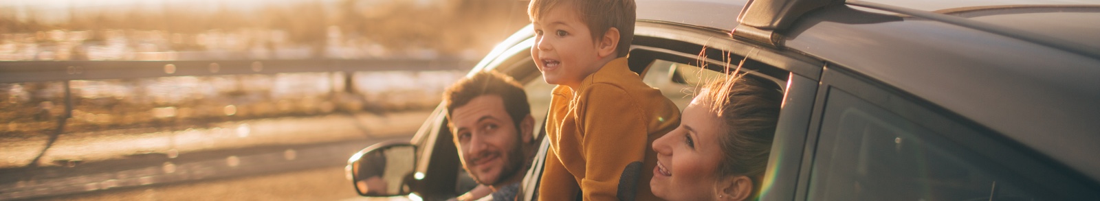 Kid outside of car window with parents