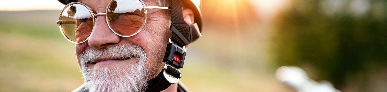 smiling bearded man in motorcycle helmet and sunglasses