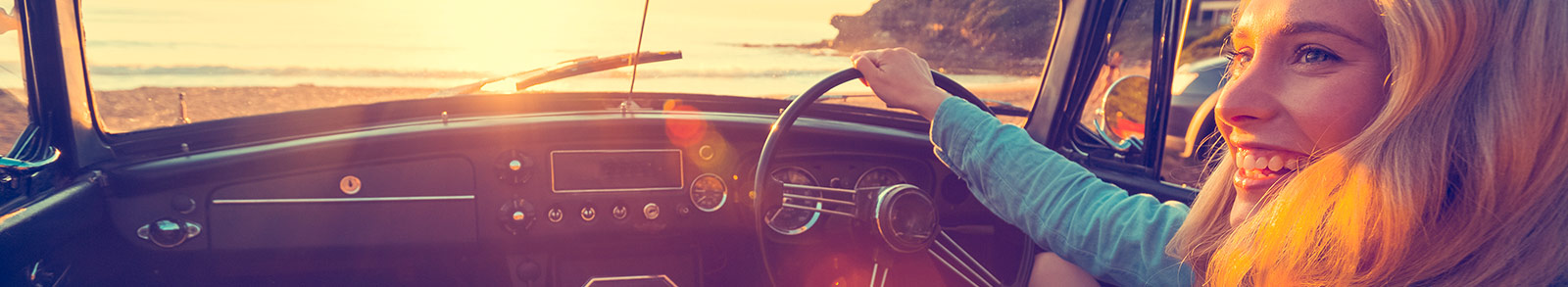 Woman driving a car at a beach