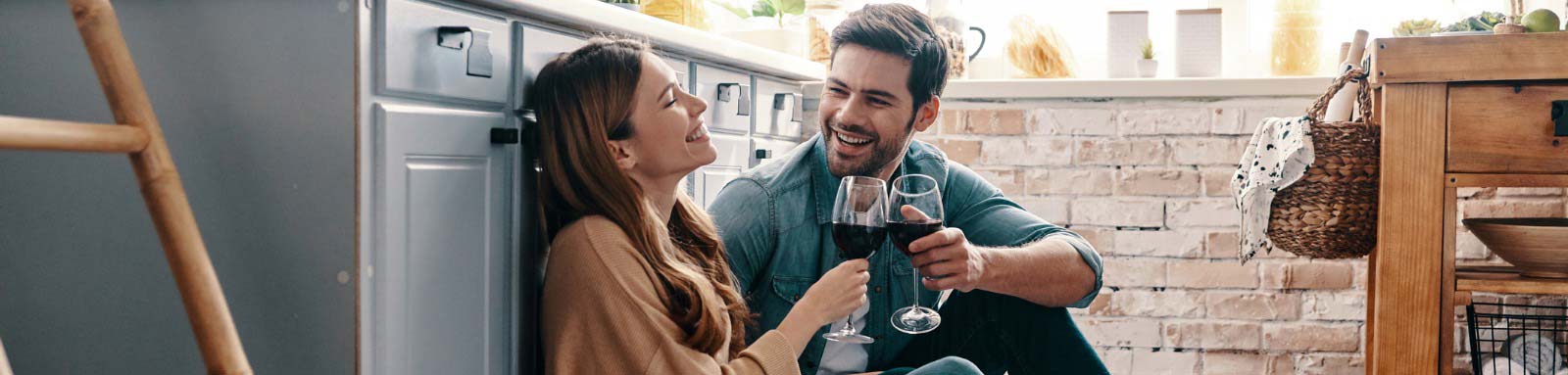 Man and woman drinking wine on kitchen floor