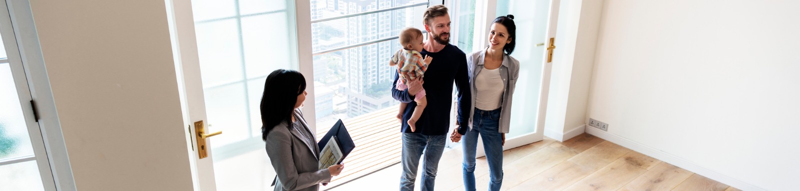 man woman and baby inspecting an empty house