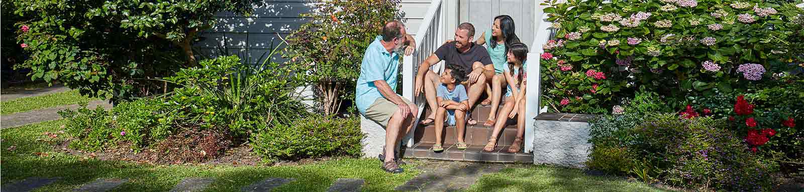 Family sitting on front steps of house