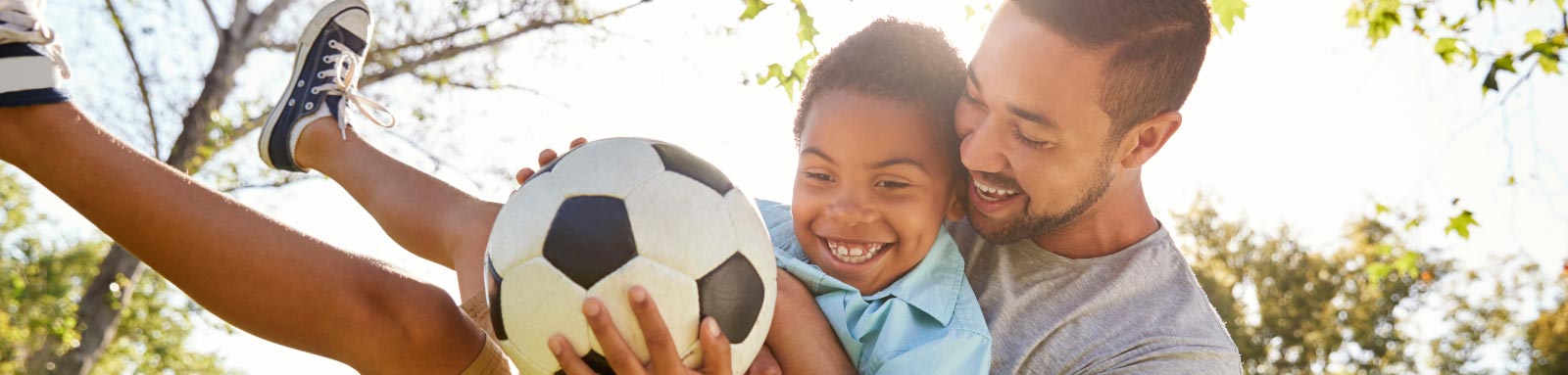 Father and son playing with soccer ball