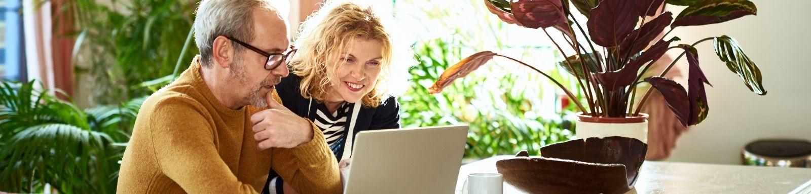 Elderly couple in their 50s looking at a laptop