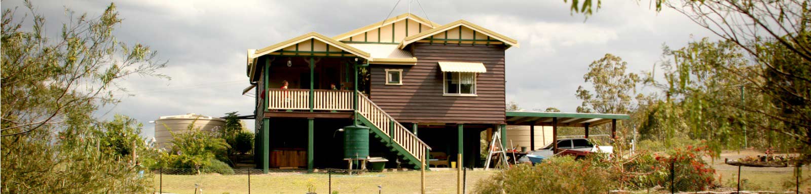 Large wooden house surrounded by bush 