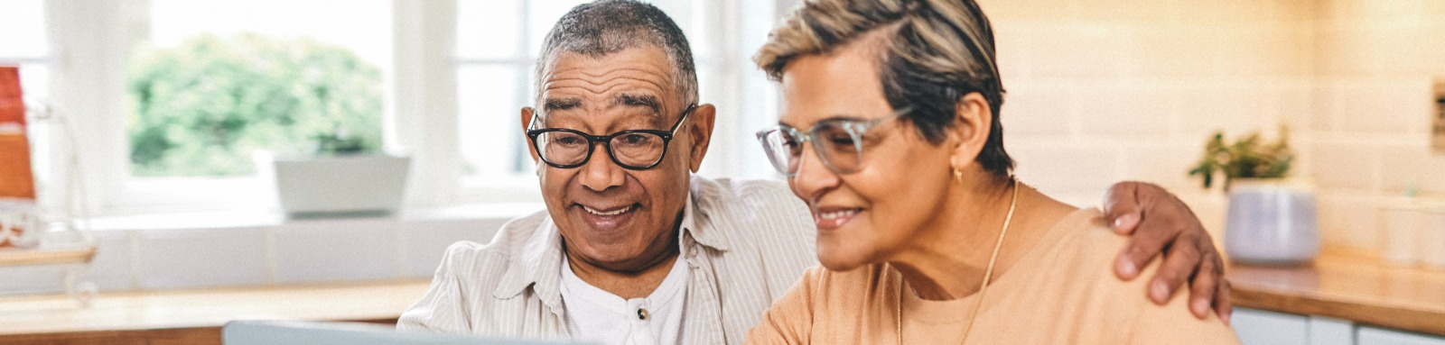 Couple sitting down reading on a laptop