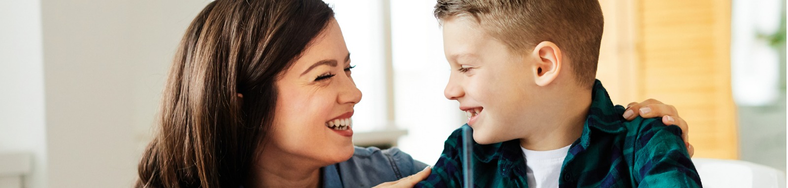 Mother and son smiling at a table