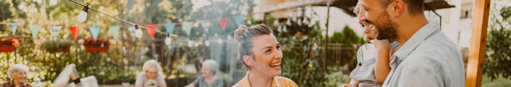 Smiling woman and man holding a child at a party