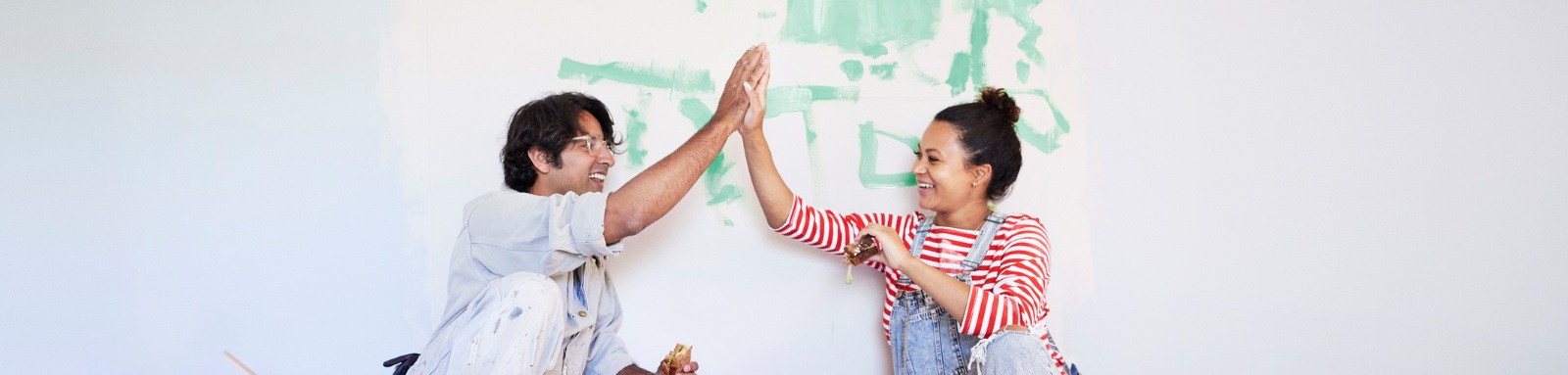 Man and woman high fiving each other during home renovation