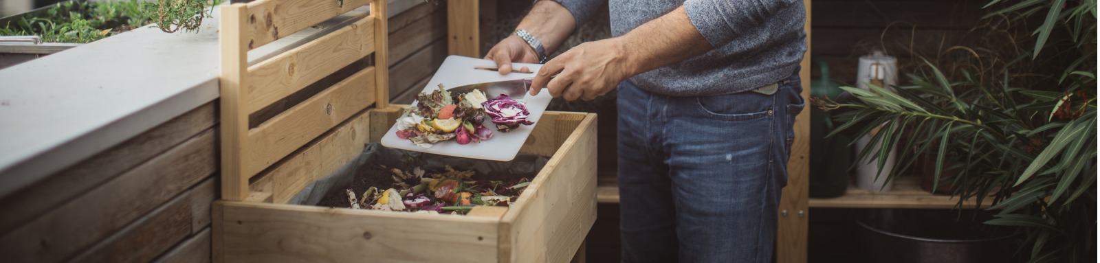 Man putting food scraps into compost bin