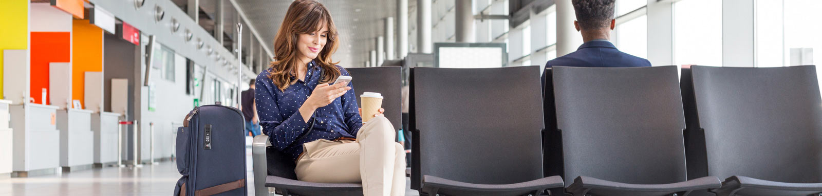 Woman holding a mobile phone at an airport lounge