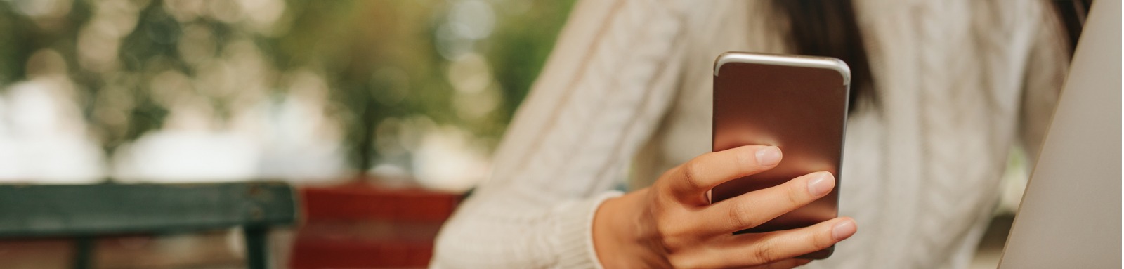 woman at cafe table checking phone