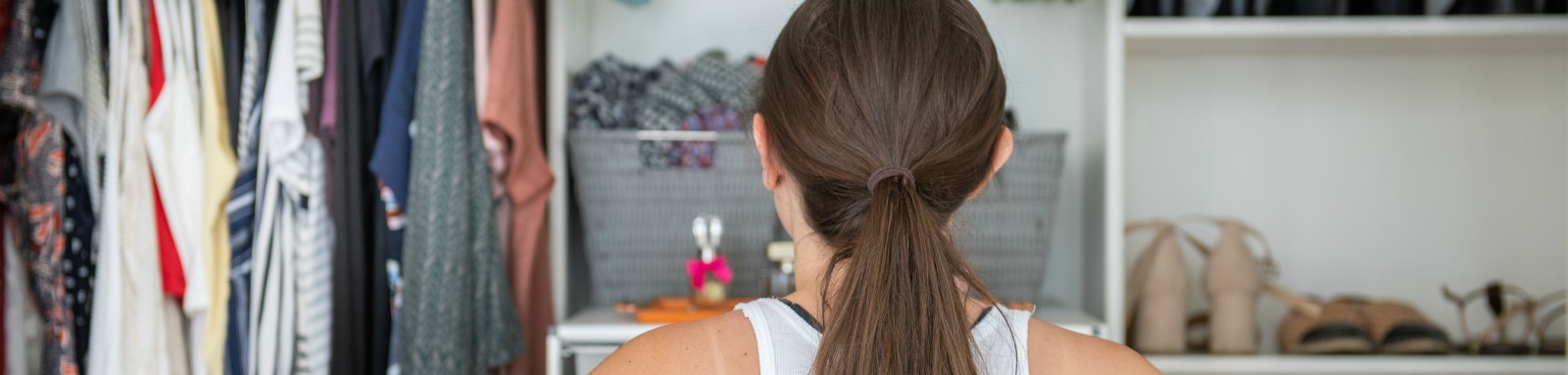 Woman looking at clothes in closet